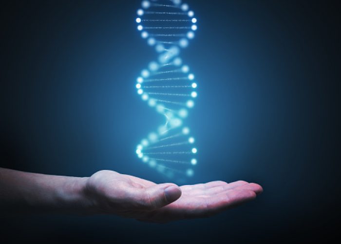 DNA and genetics research concept. Hand is holding glowing DNA molecule in hand.